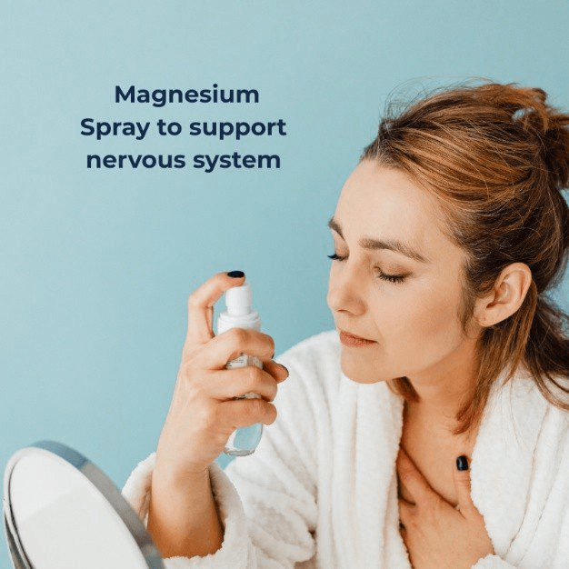 Person applying magnesium spray in front of mirror with wellness message.